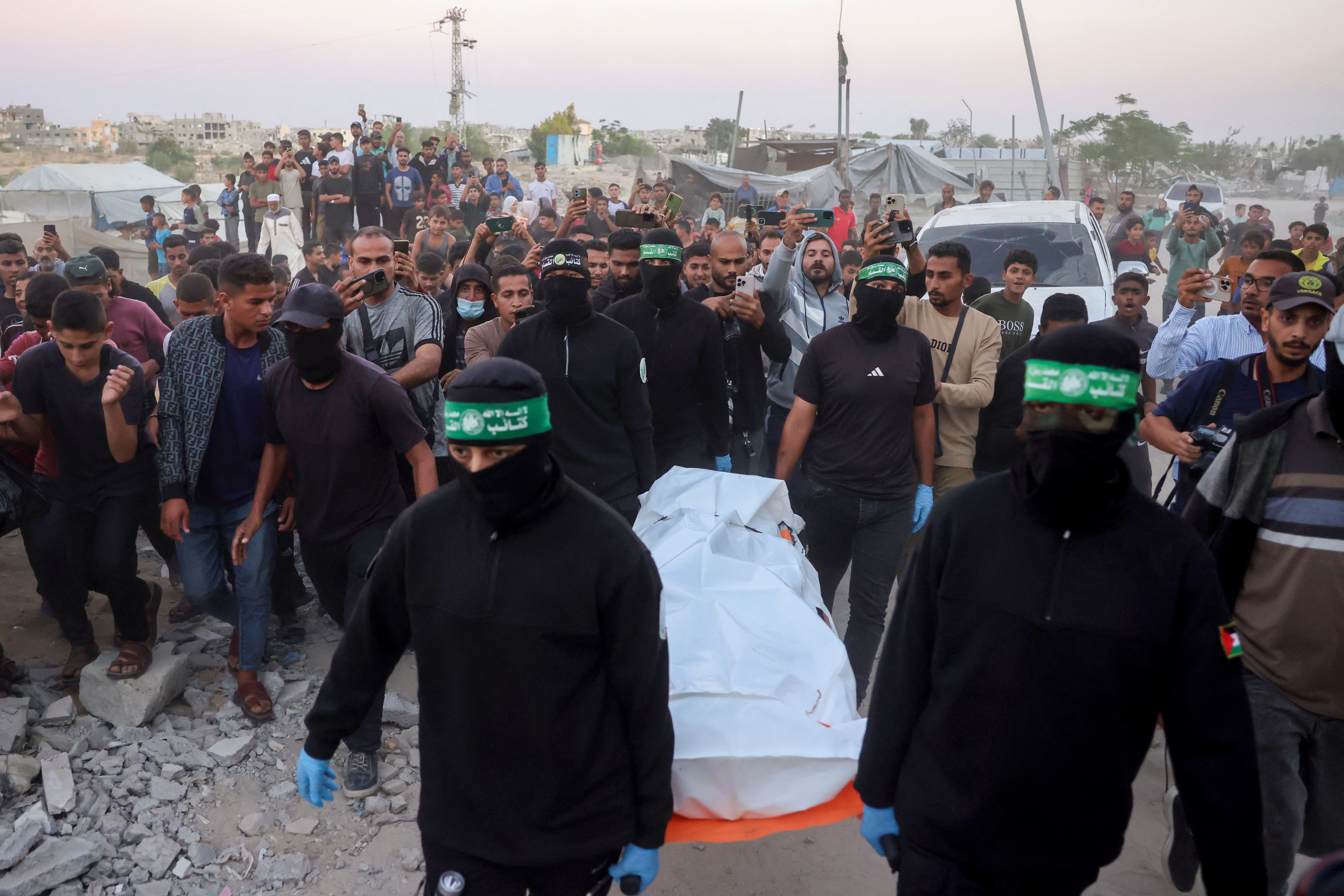 Hamas members carry a body retrieved from a tunnel in an area north of Khan Younis, in the southern Gaza Strip, on Tuesday. Israel accused Hamas of staging its search for the remains of a Gaza hostage body.